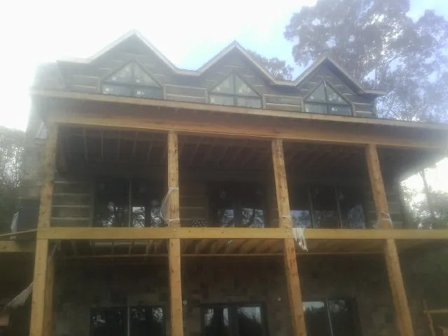 Dormers and porch framing on a large log home under construction — Roof Coating work by our crew in Wray
